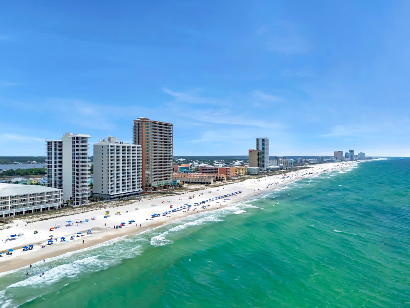 Aerial view of a beachfront condo community along turquoise Gulf water