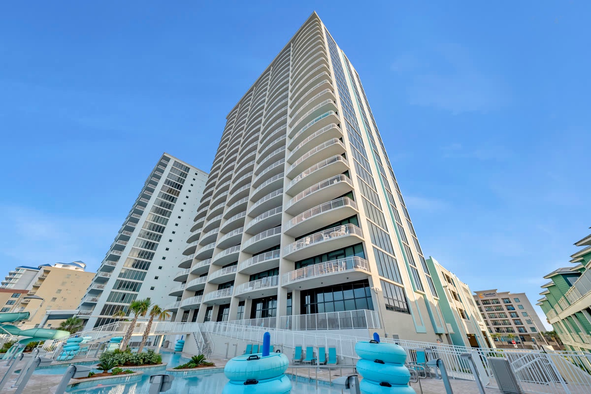 Beachfront high-rise condo tower with a pool deck below
