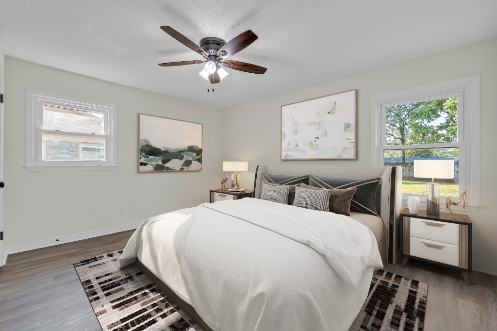 Virtually staged primary bedroom with white bedding, modern nightstands, and abstract wall art