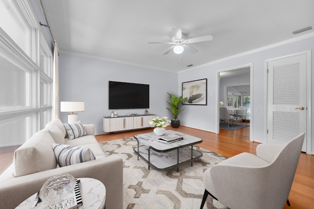 Virtually staged living room with cream sofa, marble coffee table, and wall-mounted television