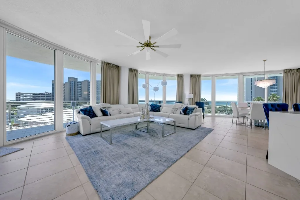 Open-concept living and dining room with floor-to-ceiling windows and coastal high-rise views